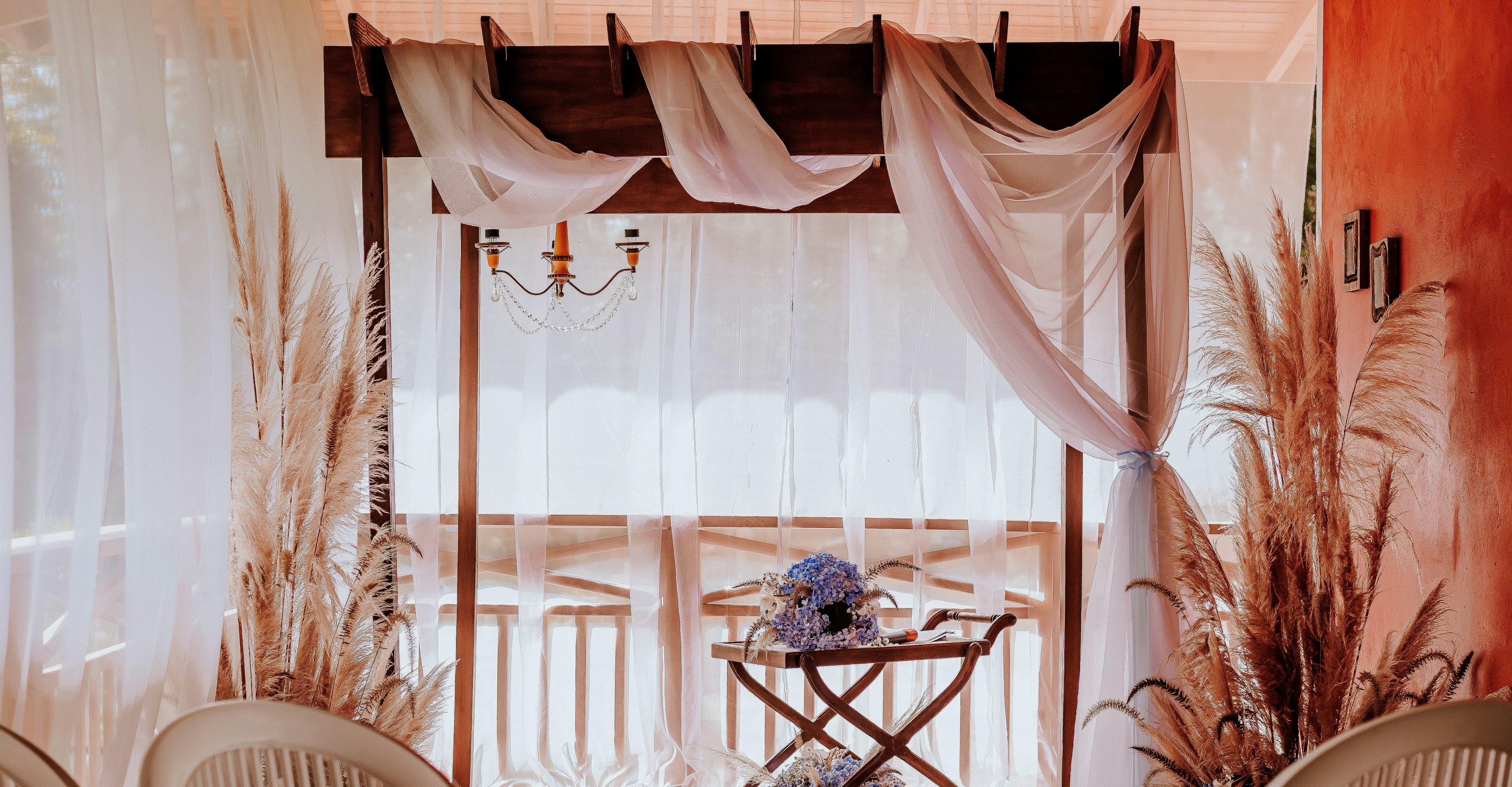 Espaço de eventos da Cabana Tapili — pergolado com cortinas, capim-dos-pampas e hortênsias